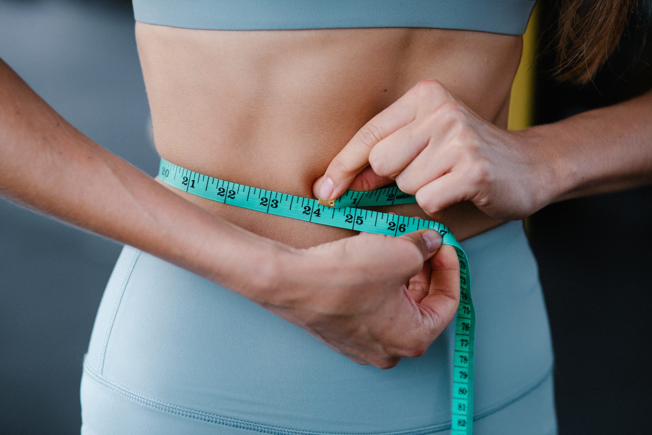 Woman checking weight measurement with tape