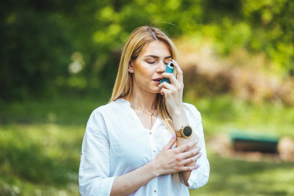 Woman using an asthma inhaler