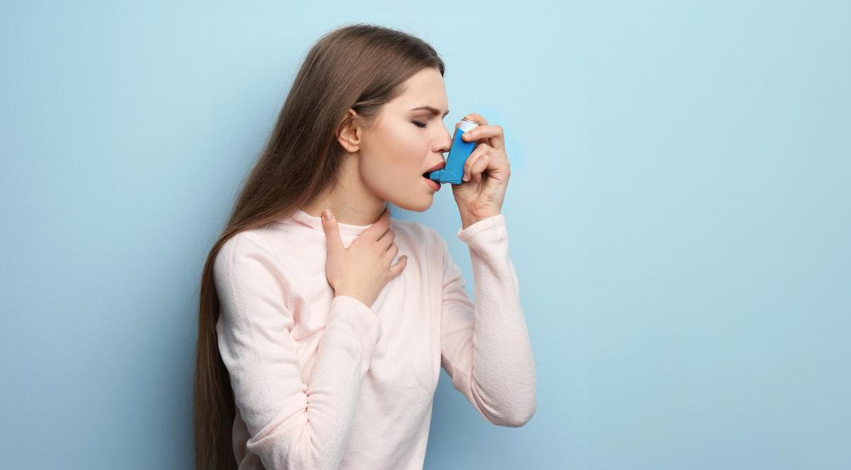 Adult dealing with asthma inhaler.