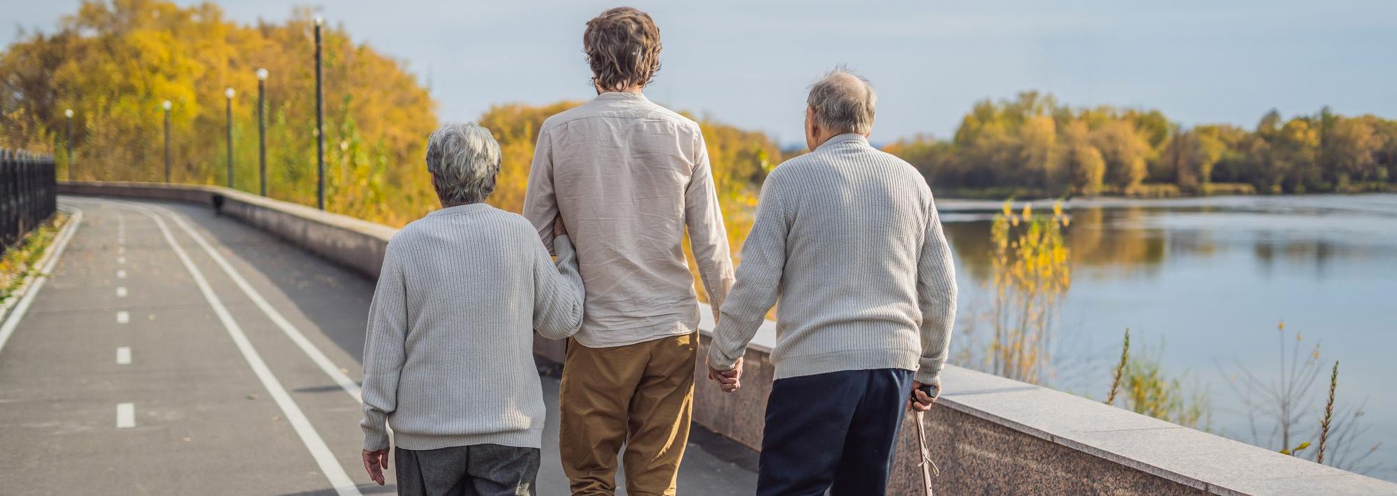 Elderly couple walks in the park with grandson.