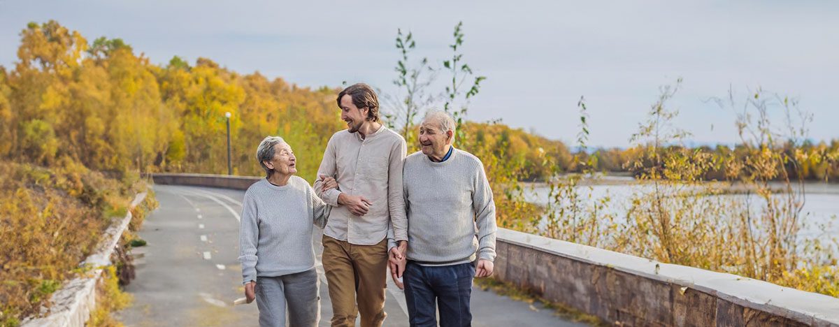 Elderly Couple Walking with Grandson ensuring they are stable.