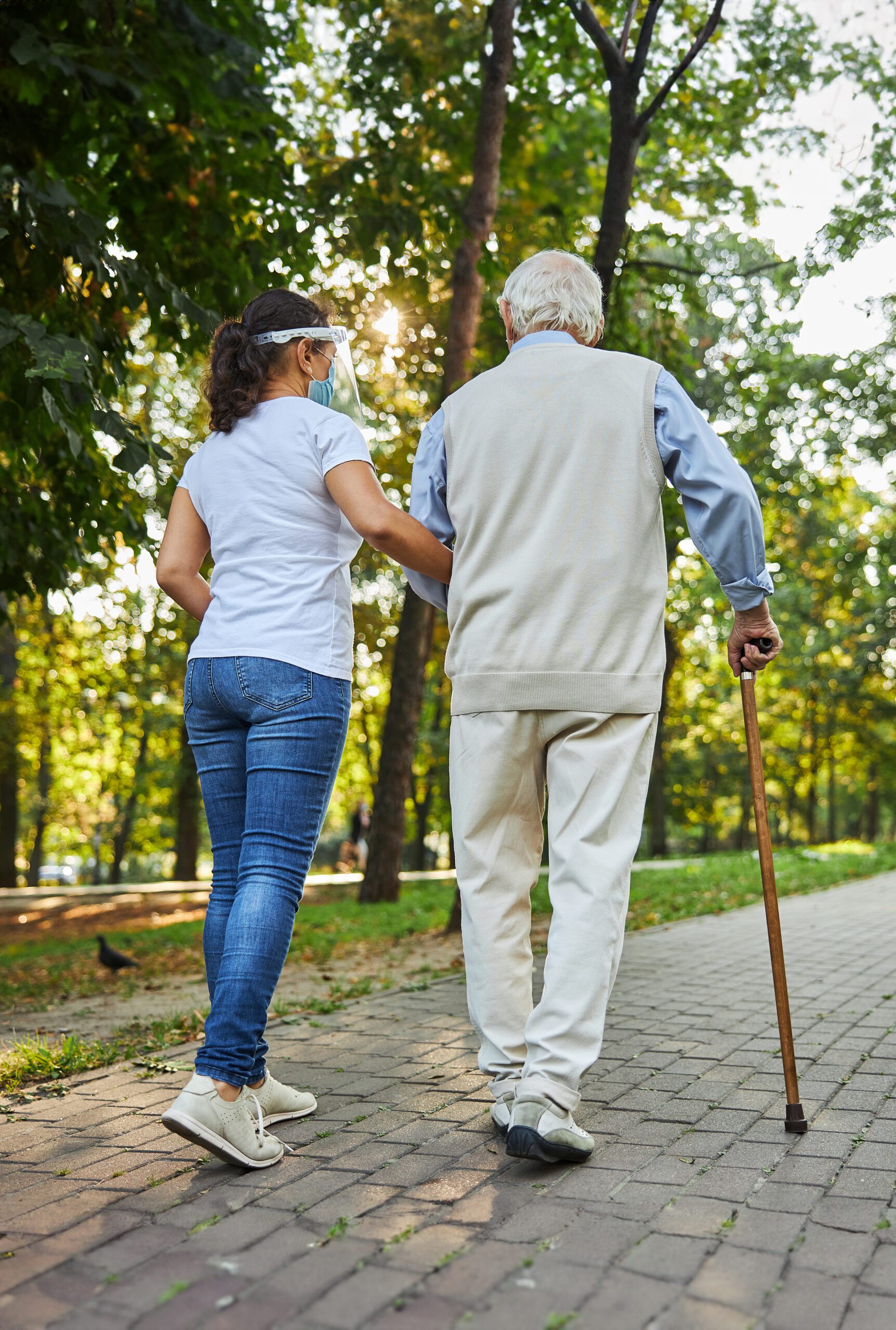 Back view portrait of mature man walking through park.