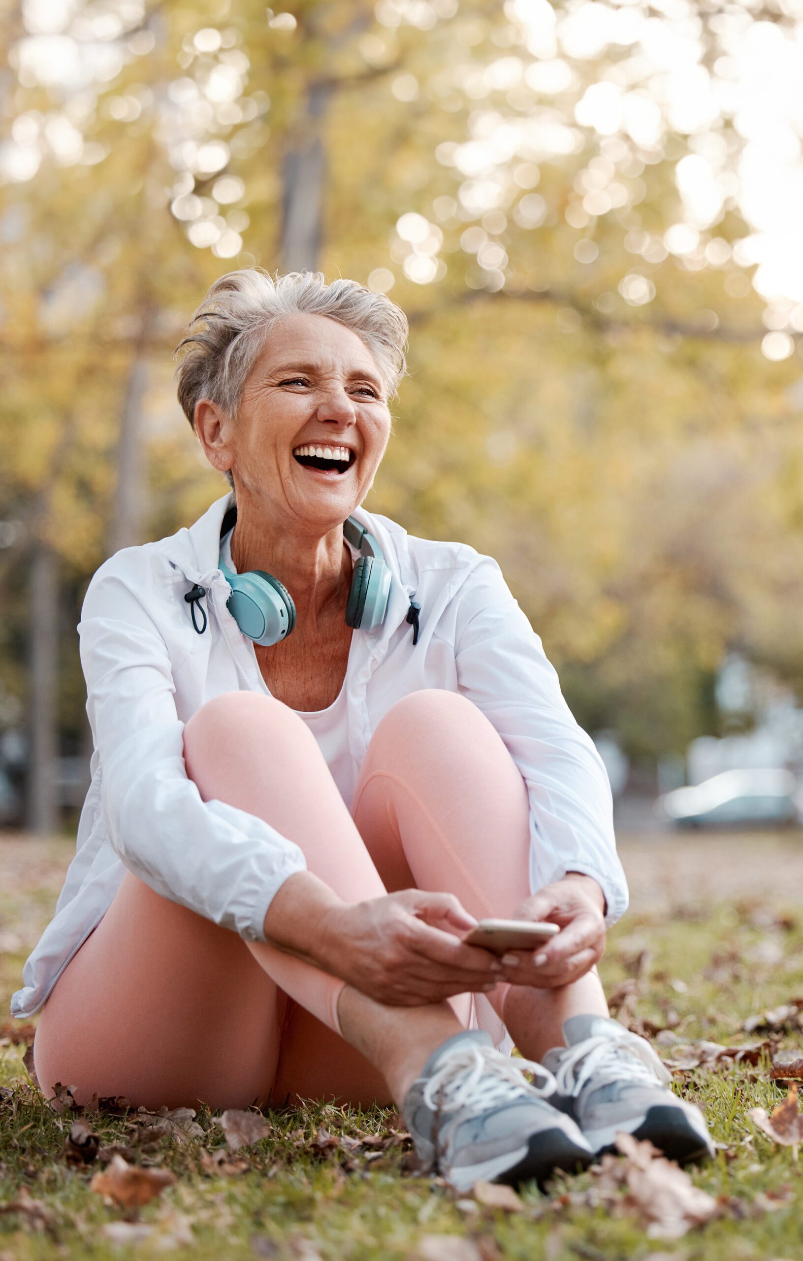 Senior woman in park sitting after exercise.