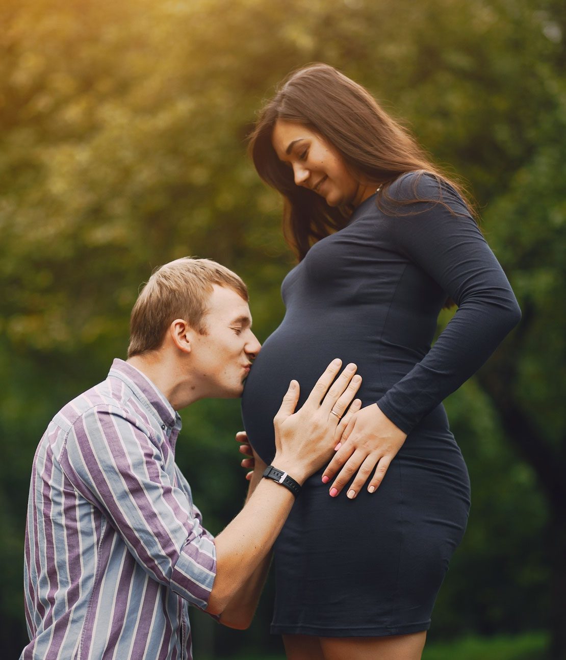 new family in a park with pregnant mom